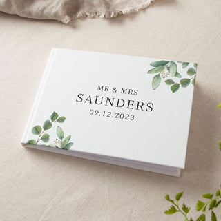 personalised white wedding guest book with printed green eucalyptus leaves