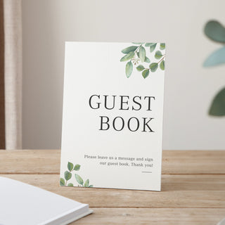 white wedding guest book sign with printed green eucalyptus leaves